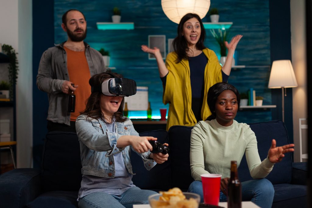 Happy gamer woman with virtual reality headset winning online competition