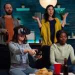 Happy gamer woman with virtual reality headset winning online competition